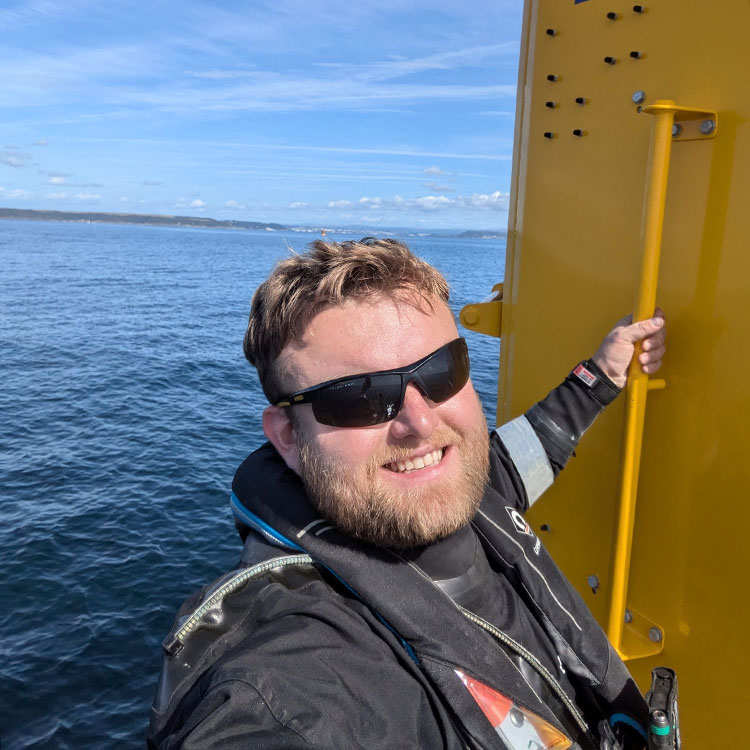 Ross Sanders hanging off a yellow data buoy