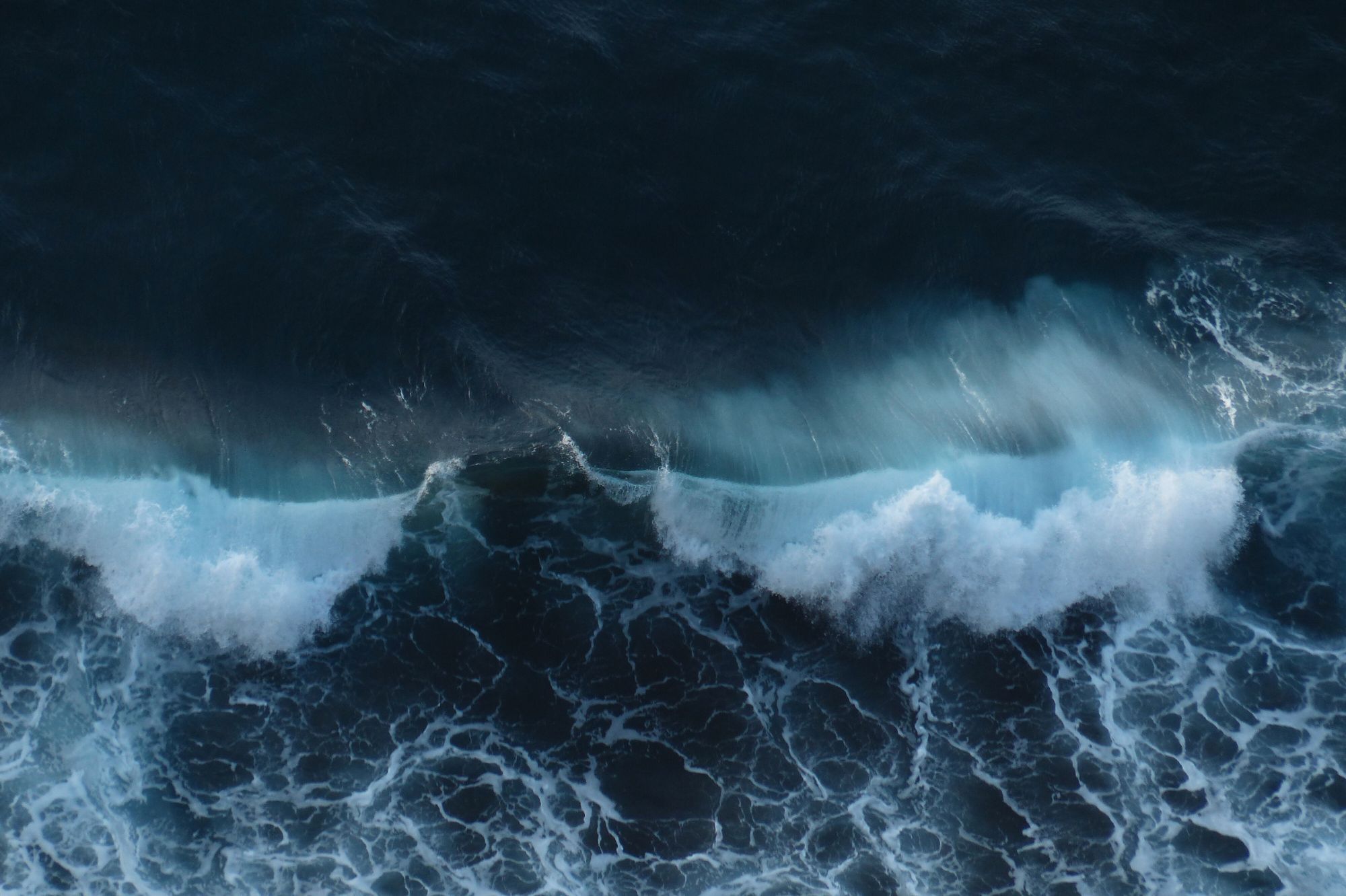 Crashing waves on a dark foreboding ocean from above